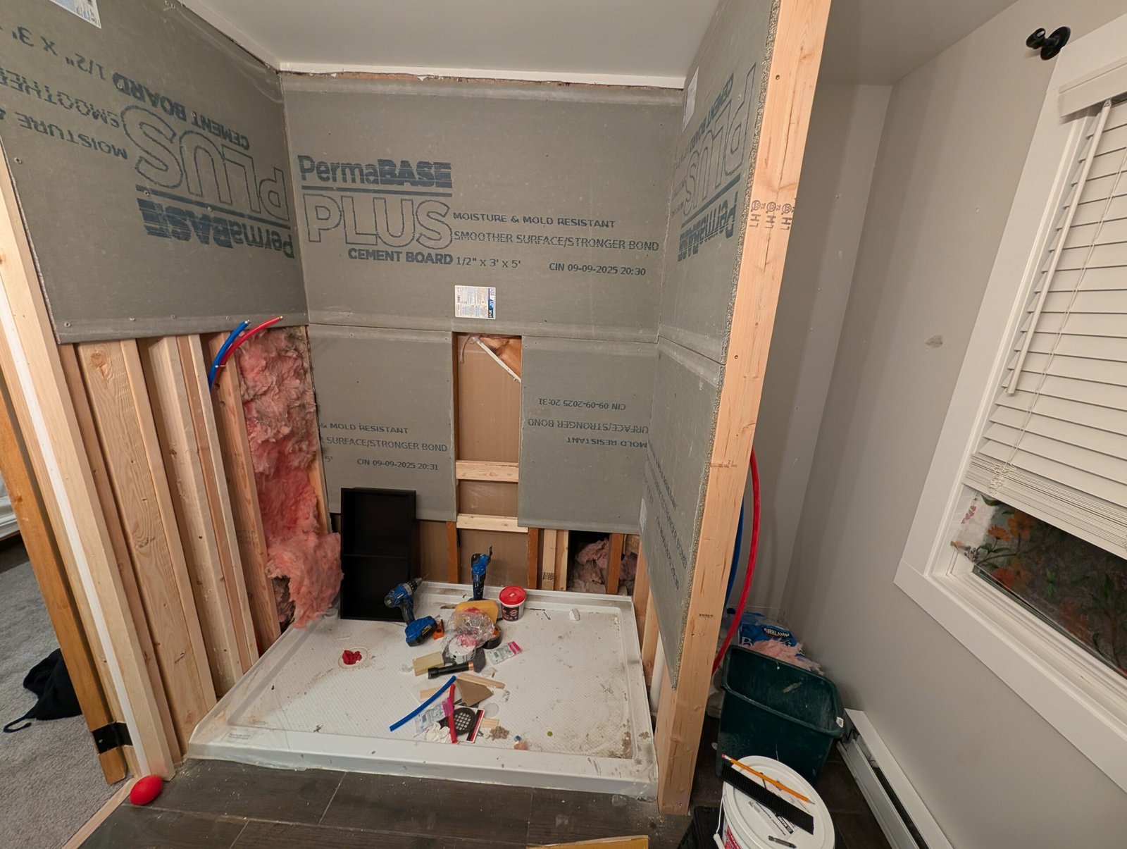 Cement board mostly up, showing the shower area taking shape with the niche opening cut out