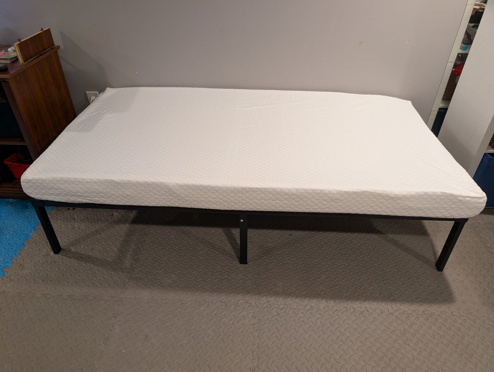 Mattress opened and laying on frame, expanding after unboxing